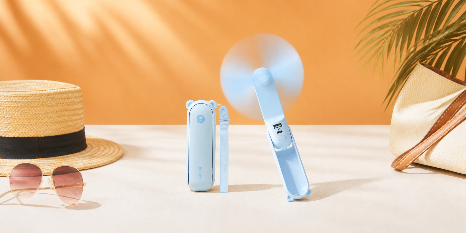 Ambientazione editoriale calda di JISULIFE, ventilatore portatile pieghevole blu con power bank. Il prodotto mantiene forma, colore e dettagli riconoscibili dell’originale.